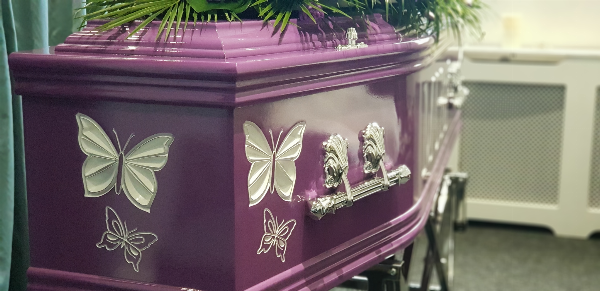 Purple coffin with engraved butterflies painted whited #personalcoffin #unique #engravedcoffin #colourfulcoffin #paintedcoffin #specialcoffin #oneofakindcoffin available at Jason O'Brien & Family Funeral Services Limited in Ashton-Under-Lyne, Greater Manchester